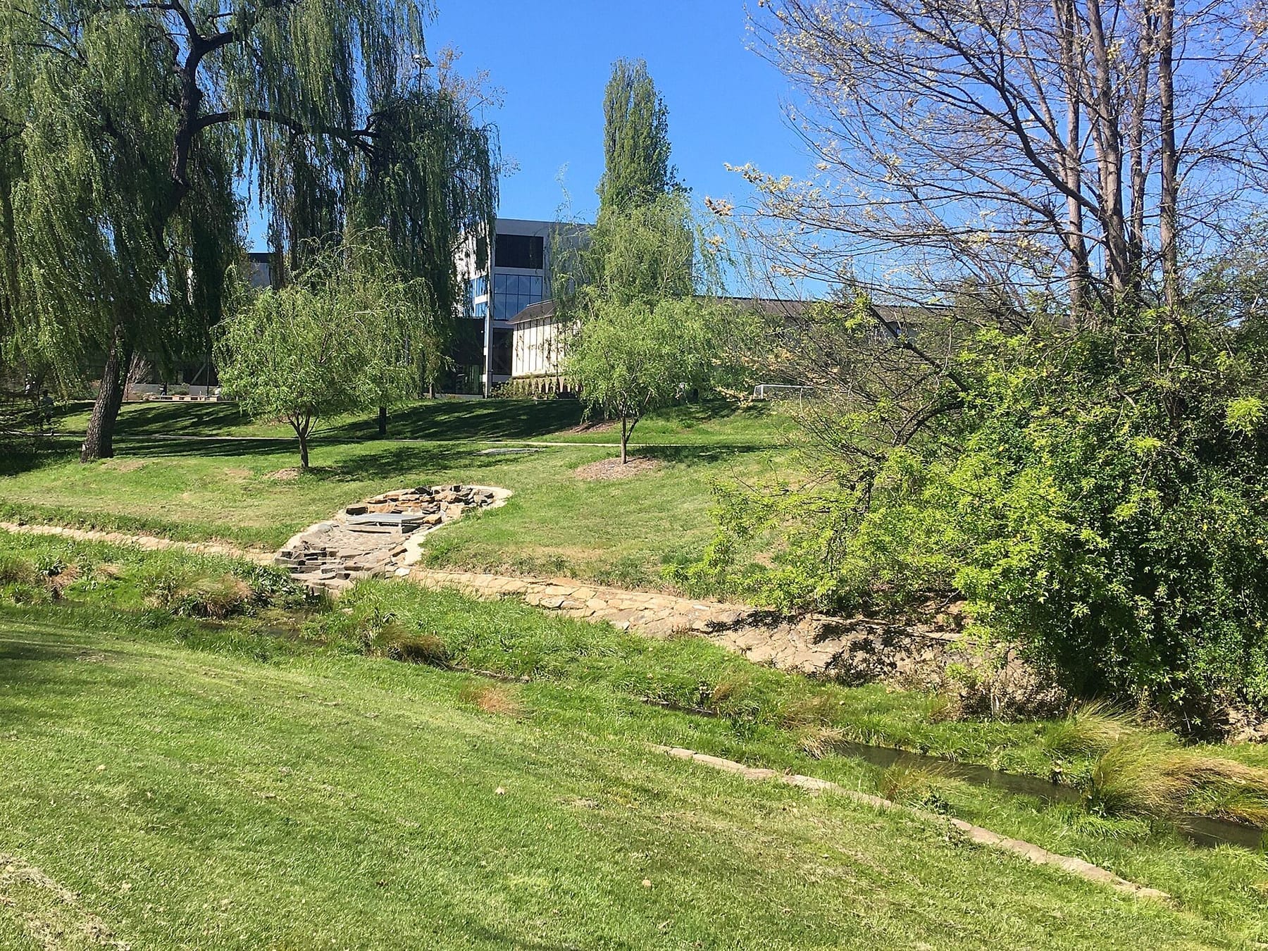 ANU - Sullivans Creek with Marie Reay Teaching Centre and Chifley Library behind (photograph from the Wikimedia Commons category Australian National University)